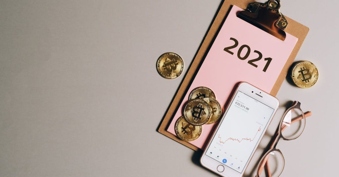 flat-lay-of-bitcoins-smartphone-eyeglasses-and-clipboard-with-2021-text-symbolizing-cryptocurren-5