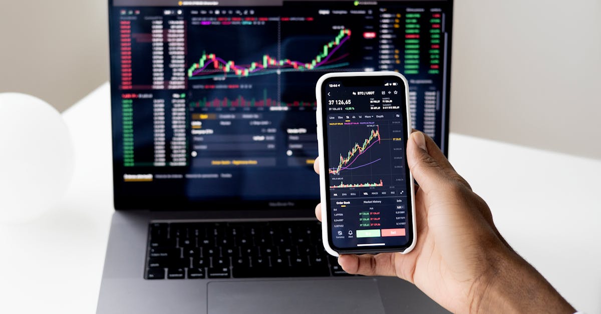 person-checking-stock-market-graphs-on-laptop-and-smartphone-focusing-on-financial-data